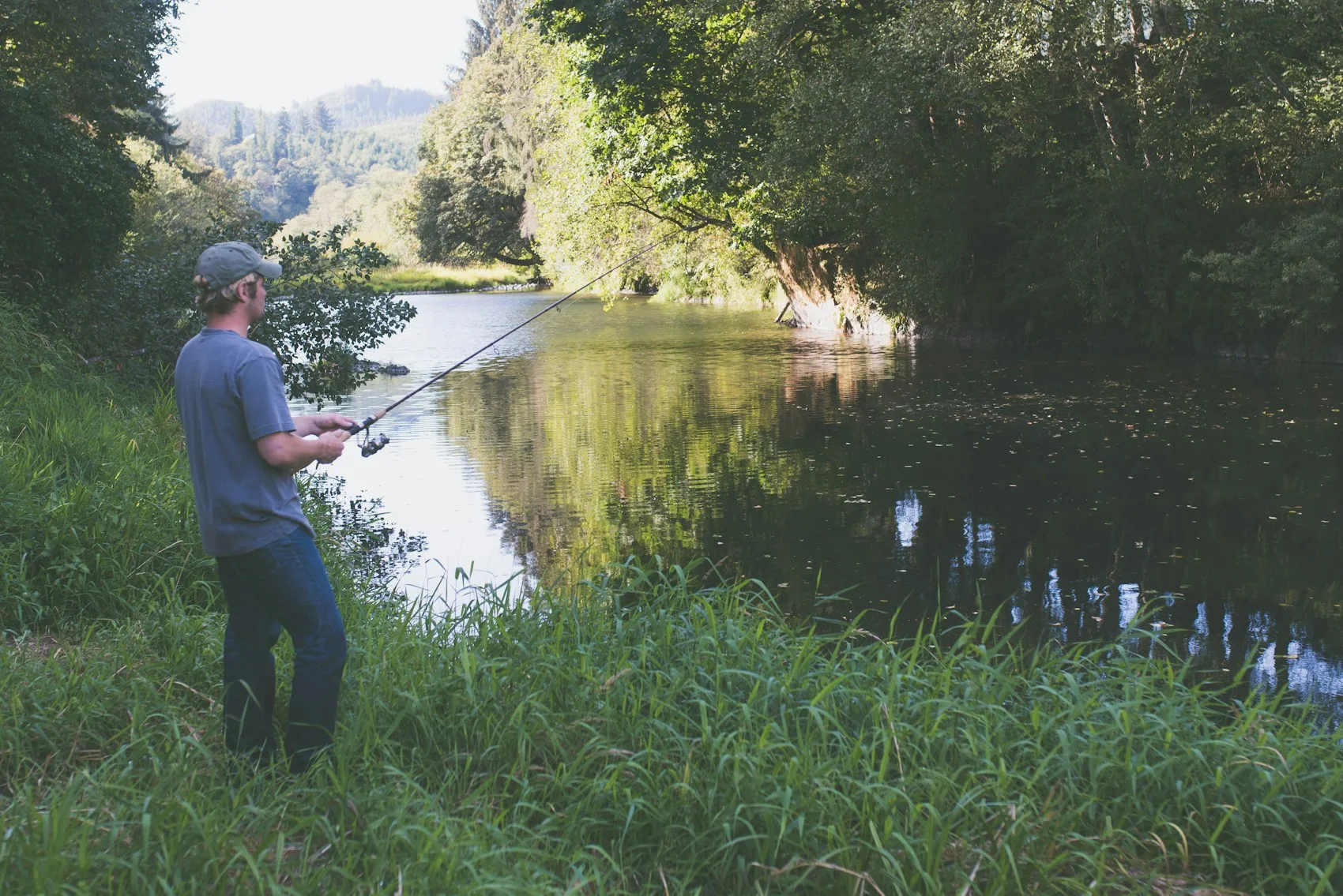 An angler beside quiet water